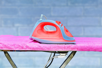 Iron lies on an ironing board with a power point.