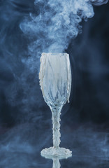 Obraz na płótnie Canvas Glass decorated with streaks of wax in the clouds of white smoke and fog. Stylized drinks for Halloween