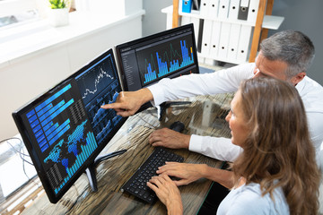 Stock Market Broker Analyzing Graphs On Laptop