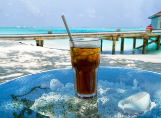 A glass of cold cocktail on a table on the beach in a restaurant