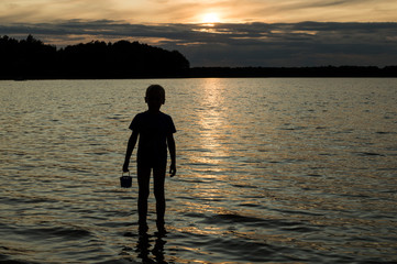 Sunset shadows. Shadows of children who are playing in the lake on the water in last sunshine.