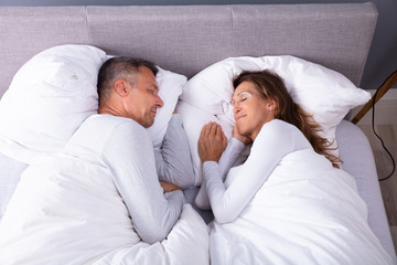 Couple Sleeping On Bed
