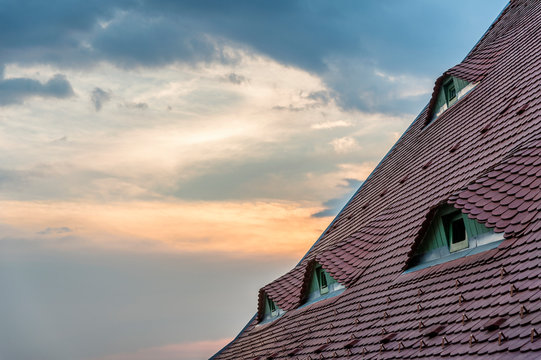 Traditional house with windows shaped like eyes on the roof, in Sibiu (Romania) during sunset.