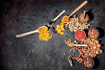 Fototapeta na wymiar Mix of nuts and dried fruits on dark background. Healthy food and snack