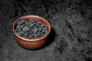 Wooden bowl with dried fruits on dark background. Healthy food and snack