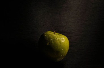 Green apple on black background