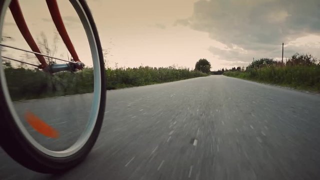 Cyclist rides on an asphalt road in the country