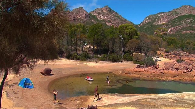 Hikers set up a camp with ten along the shore of Coles bay, Tasmania, Australia.