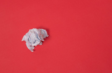 crumpled paper ball  on a red background