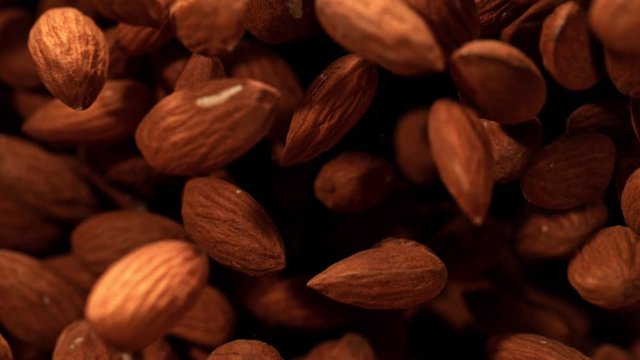 Super Slow Motion Shot of Almonds Flies After Being Exploded against Black Background, 1000fps. Shooted with High Speed Cinema Camera at 4K.
