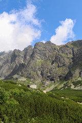 View of mountain peaks in summer time in High Tatras with cloudy sky.