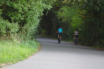 Fototapeta na wymiar Ein paar macht ein Fahrrad-Tour im Wald und fährt durch ein Baum-Tunnel