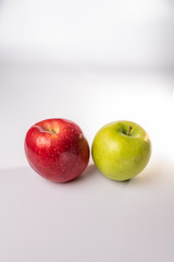 Red delicious and green granny smith apples isolated against a white background