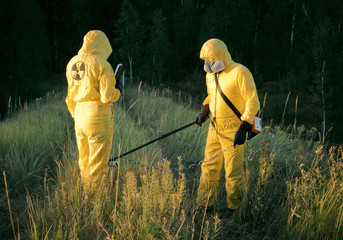 Two dosimetrist  in protective suite and mask with geiger counter measuring radiation level in danger zone - 285729095
