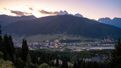 Night view on Mestia with its beautiful illuminated Svan Towers and high mountains. Svaneti, Georgia.