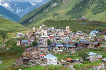 Fototapeta na wymiar View of the Ushguli village at the foot of Mt. Shkhara. Picturesque and gorgeous scene. Rock towers and old houses in Ushguli, Georgia.