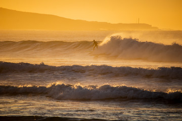 A surfer riding waves on the beach