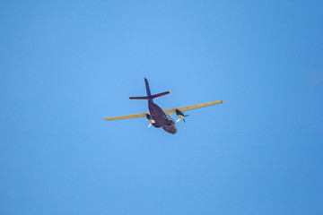 Naklejka na ściany i meble Flying airplane on a blue sky. Flying over Svaneti, Georgia.