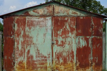 old colored metal garage with closed gates on the street
