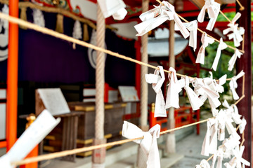 Omikuji, fortune slits tied at the place in Shiota hachiman-gu shrine in Kobe, Japan