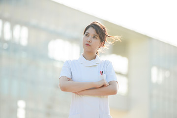 疑問を感じるポーズをする白衣の女性