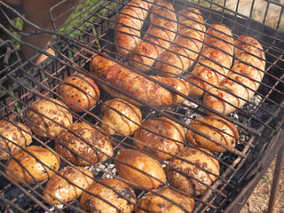 grilled potatoes and meat sausages,concept outdoor activities, charcoal barbecue in nature , street food