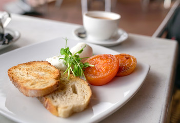 Healthy breakfast with poached eggs, tomatoes and toast bread