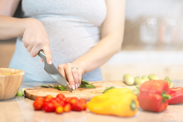 Obraz na płótnie Canvas Eat smart. Young pregnant woman is preparing a salad. Copy space in upper right part