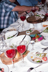 People sit at the festive table with food and drinks in the restaurant