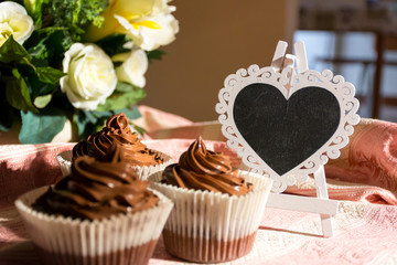 Composition of Three Chocolate Cup Cakes and a Heart-Shaped Blackboard