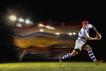 New star of the competitive. One caucasian man playing rugby on the stadium in mixed light. Fit young male player in motion or action during sport game. Concept of movement, sport, healthy lifestyle.