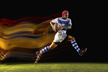 Ready for winning. One caucasian man playing rugby on the stadium in mixed light. Fit young male...