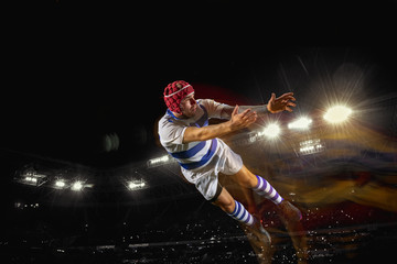 Ready to fly for win. One caucasian man playing rugby on the stadium in mixed light. Fit young male...