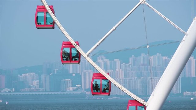 Red Ferris wheel against cloudy blue sky. Close up sky wheel in Hong Kong. City scape. 