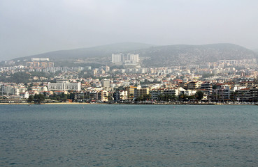 The Coastline of the city of Kusadasi, Turkey as seen across the water on a hazy foggy day.