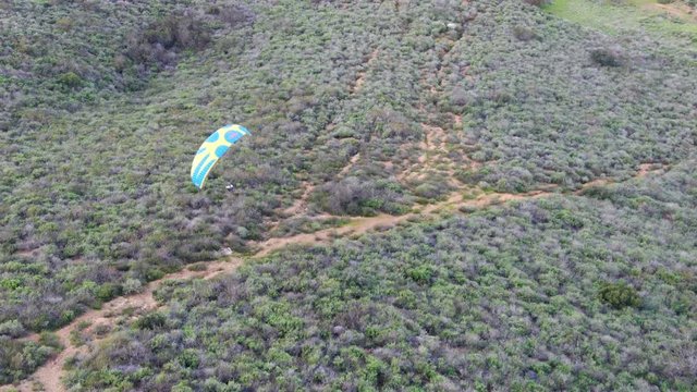 Para-glider over the top of the mountain during summer sunny day. Para-glider on the para-plane, strops -soaring flight moment flying over Black Mountain in San Diego, California. USA