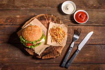 Tasty grilled homemade burger with beef, tomato, cheese, cucumber and lettuce. Delicious grilled...