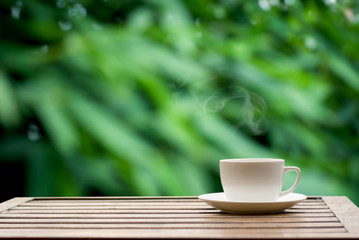 Coffee espresso on wood table nature background in garden,warm tone
