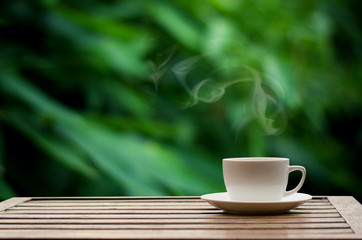 Coffee espresso on wood table nature background in garden,warm tone