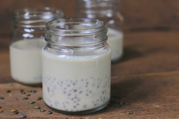 black sesame soy milk in glass on wood