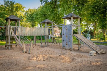 a wooden climbing frame stands on the premises of a kindergarten