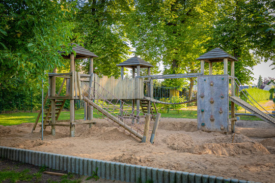 a wooden climbing frame stands on the premises of a kindergarten