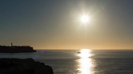 A sailboat enters the harbor of Portocolom