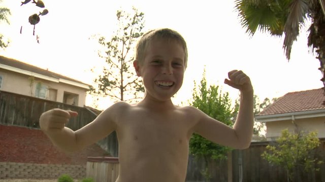 A boy poses like a bodybuilder.
