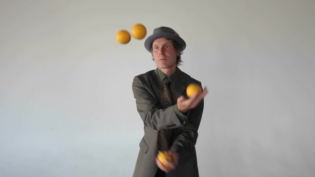 A man is juggling four balls.