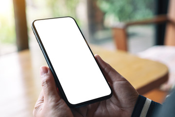 Mockup image of hands holding black mobile phone with blank desktop screen