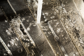 Drops of water falling on silver surface, sink in kitchen