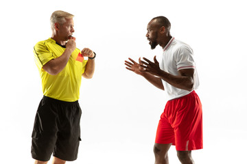 Referee showing a red card to a displeased african-american football or soccer player while gaming...