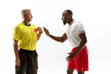 Referee showing a red card to a displeased african-american football or soccer player while gaming...