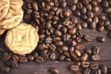 Coffee beans, cookies and book on a dark wooden table